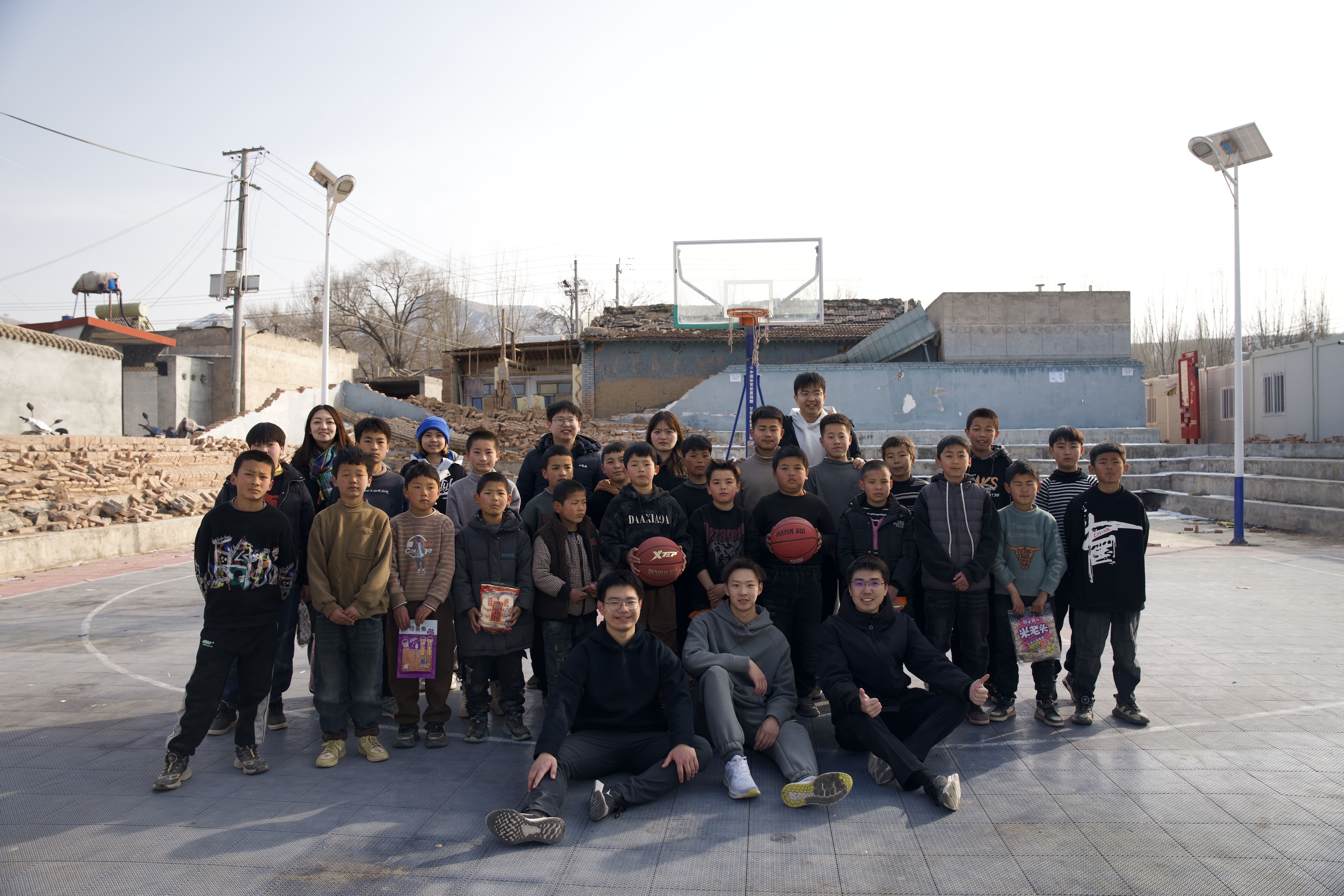 20240219-学思践悟挺膺行,青春建功新时代——2024年华体会网页版研究生寒假社会实践纪实(一)-“社稷担当·心泽河州”实践支队-支队成员在在震区球场组织开展“青少年村BA”篮球赛.jpg
